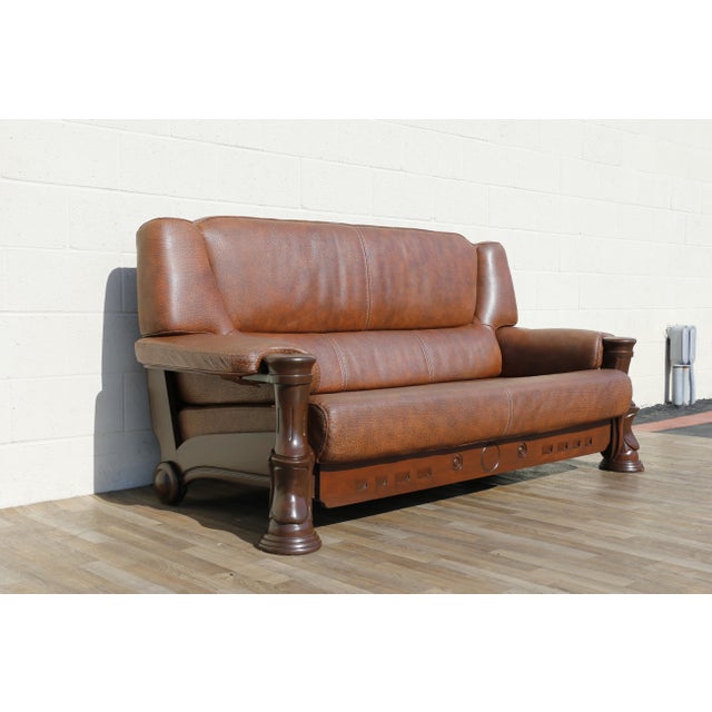Striking vintage 1970s leather sofa featuring a bold sculptural wood frame and beautifully textured brown leather...