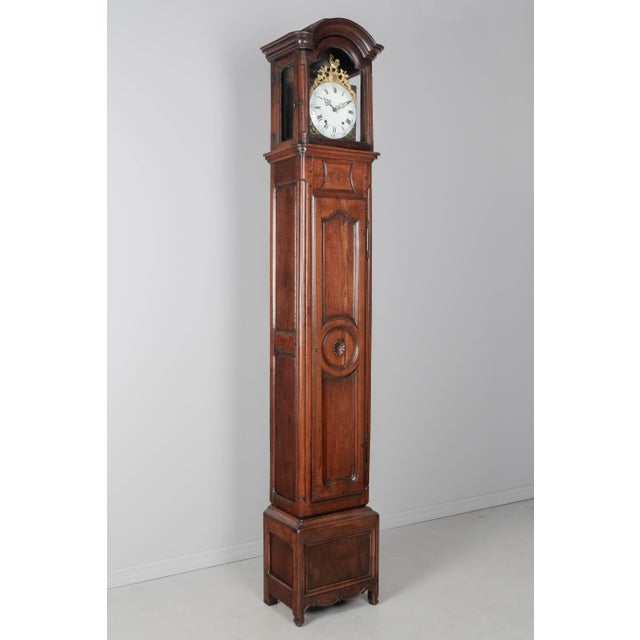 A 19th century Louis XV style French walnut horloge de parquet, or tall case clock, in two parts. The body has a paneled...
