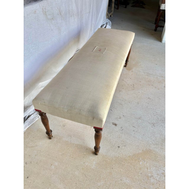 Found in the South of France, this Early 20th Century French Walnut and Antique Linen Upholstered Bench was crafted in the...