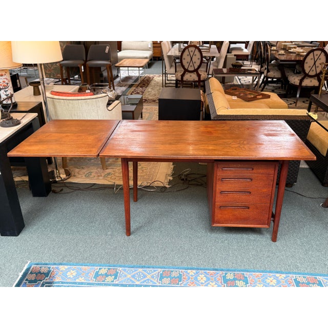 Design Plus Gallery presents a Danish Design Office Desk with Extension. The desk is made of teak wood with an auburn...