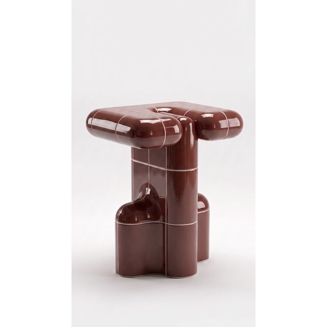 A side table with the presence of a small monument. Stacked curved tiles give it a silhouette that changes from every...