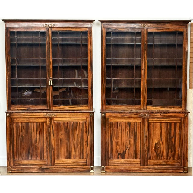 A very fine and unusual pair of English two-tiered bookcases of figured wood from the Edwardian era, crafted in the...
