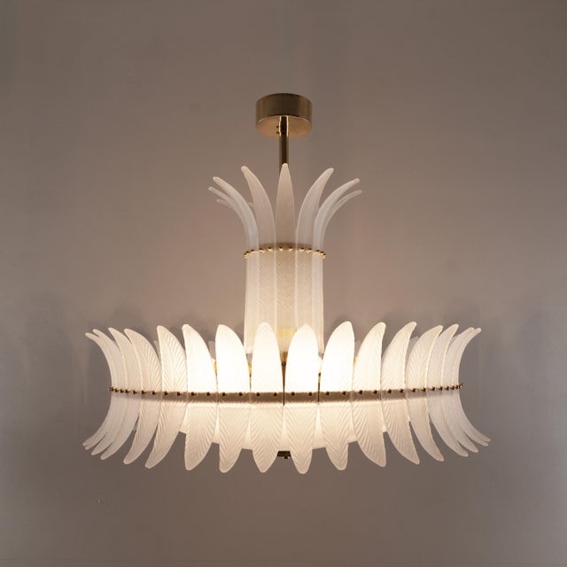 An elegant italian art deco chandelier, composed of individually handcrafted white murano glass feather-shaped elements...