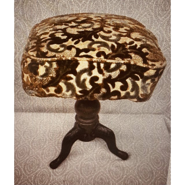 Antique Victorian (1837-1901) adjustable piano stool with a carved wooden and cast iron pedestal, claw feet and a tripod...