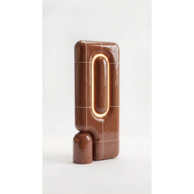 The vertical one. Where the rest of the collection sits low and grounded, this table lamp rises in a slim column of curved...