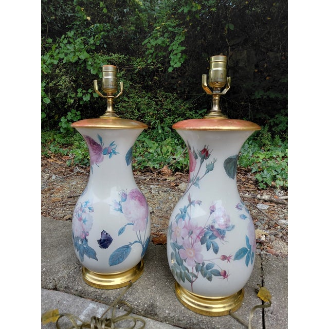 An elegant pair of vase-form ceramic table lamps attributed to Vaughan Designs, featuring pink and lavender roses with...