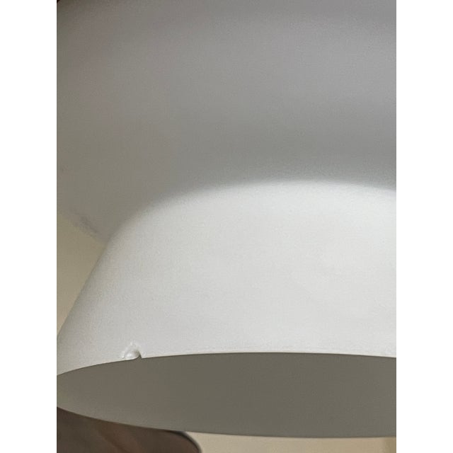 A rare three-light pendant lamp, featuring a modernist design dating back to the 1960s. Its design is centered on a...