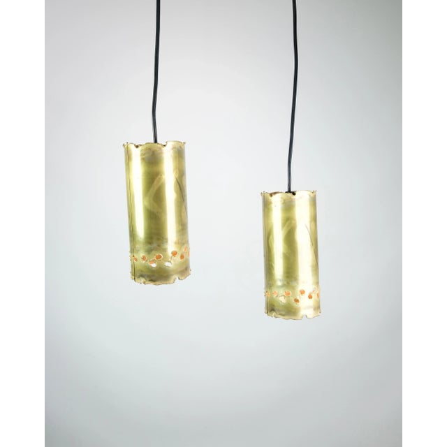 The brass ceiling lamp, characterized by a characteristic cylinder shape and a black cord, is a remarkable example of...