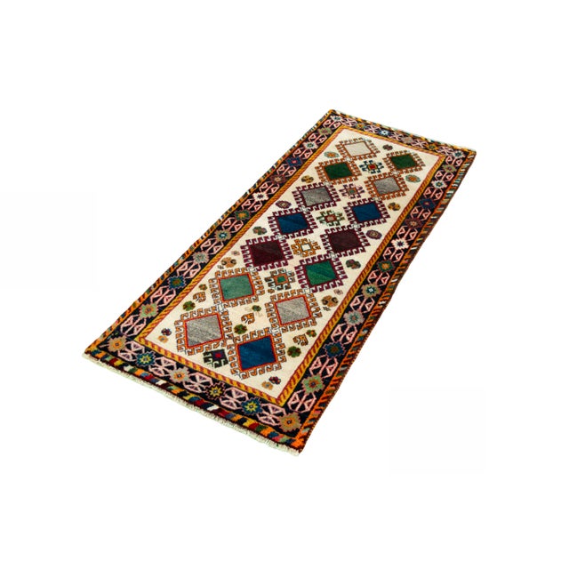 This hand-knotted Gabbeh nomad rug impresses with its expressive geometry and colorful design. The diamonds in different...