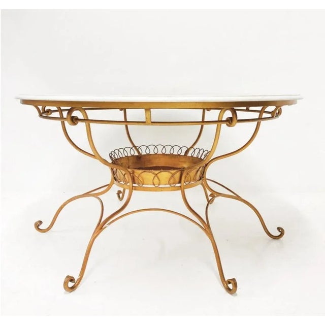 Italian round table with white marble top 20th century supported by wrought iron legs. 20th century. Dimensioni 73,5x132...