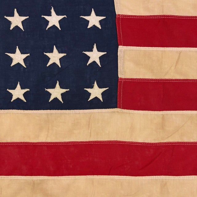 This vintage American flag is made from a thin cotton cloth with fully sewn stars and stripes. Please note overall...