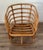 This vintage bent rattan lounge chair features a beautifully sculptural frame with gracefully curved arms and stacked...