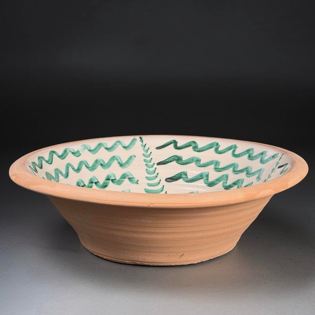 A large Spanish hand-painted earthenware lebrillo bowl executed in the traditional Fajalauza style. The bowl is decorated...