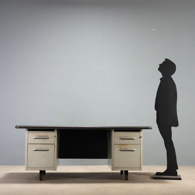 1960s desk featuring a solid lacquered metal structure, typical of the industrial design of the era. The top is enhanced...