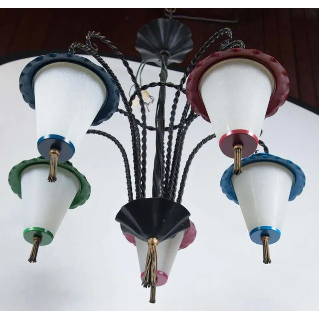 Wrought iron chandelier with five hanging Japanese style lanterns. Lanterns are milk glass with metal tops and metal...