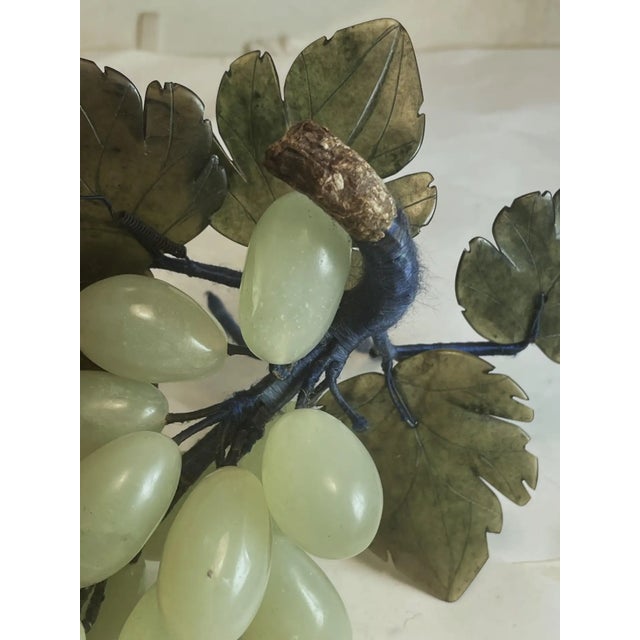 This is a realistically carved jade bunch of grapes with darker jade carved leaves. The stem network is wire wrapped with...