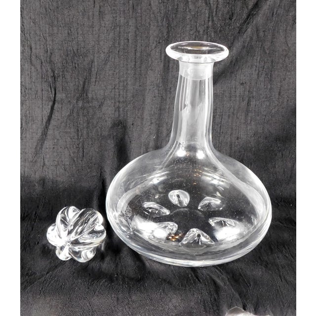 This is a signed Orrefors decanter in an unknown pattern. The decanter is large and heavy with a petal shaped cut in the...