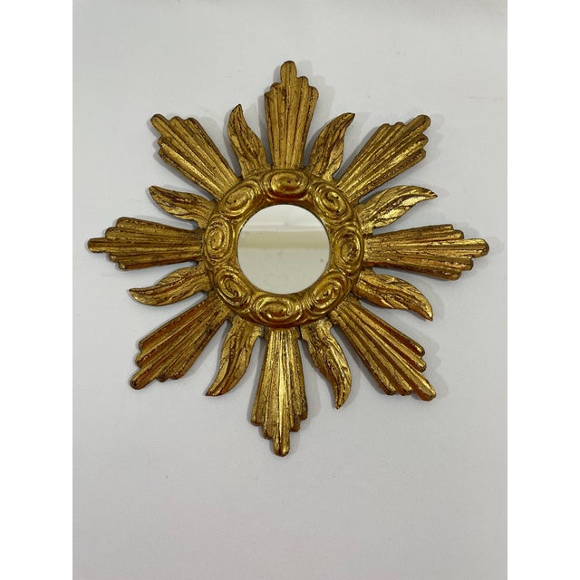 A splendid hand carved petite 11" diameter French Giltwood Sunburst Wall Mirror, circa 1950s. The center 2.25" flat mirror...