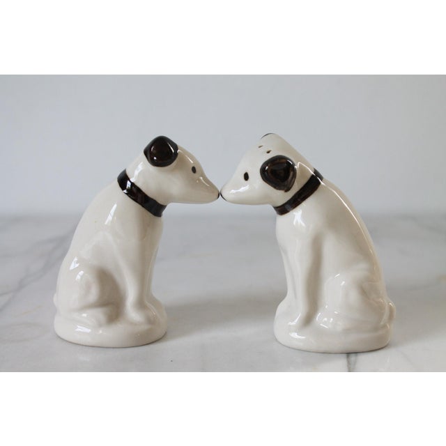Pair of vintage black and white dog salt & pepper shakers. No makers mark. Cork may need to be replaced. No chips or cracks.