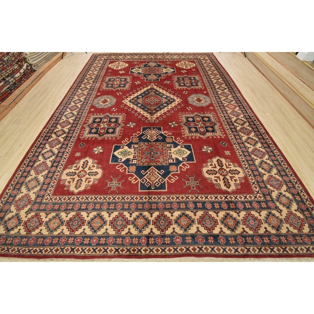 A tribal Caucasian Kazak rug hand-knotted with fine wool on a cotton foundation. This oriental rug features a central...