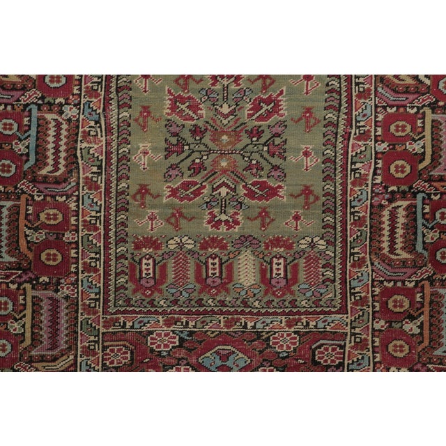 Hand-knotted in wool, this 4x6 Vintage Turkish Anatolian Prayer Rug, circa 1950–1959, features a soft olive mihrab framed...