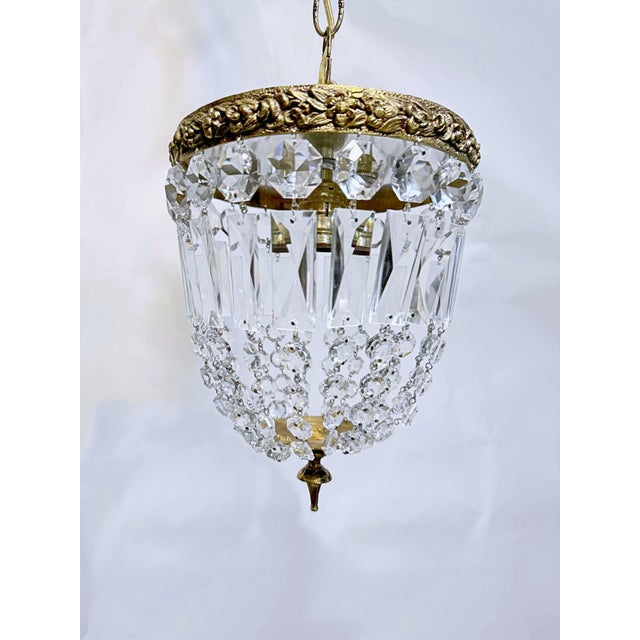 This is adorable vintage brass frame basket chandelier with graduated crystal chain. It has one Edison based socket that...