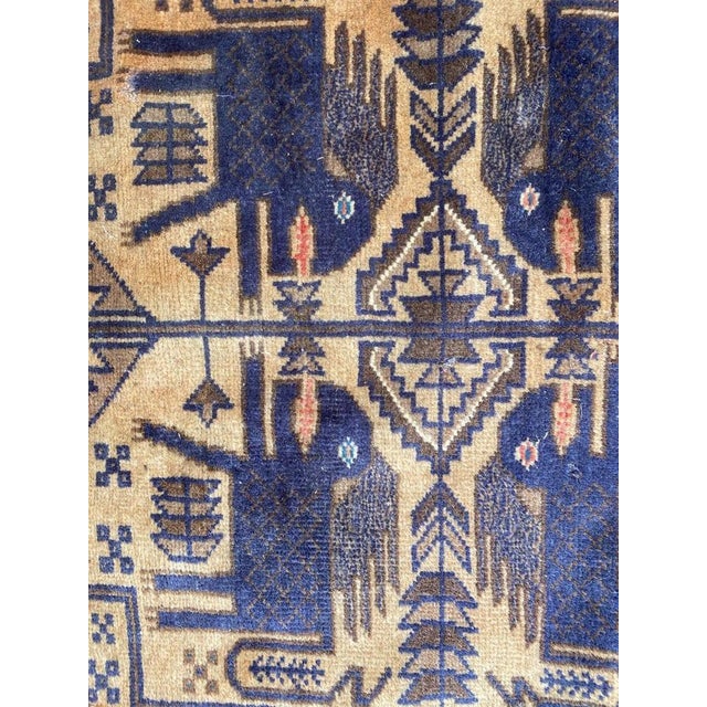 Beautiful vintage Afghan Belutch rug with a tribal design and blue, green and yellow colors, entirely hand knotted with...