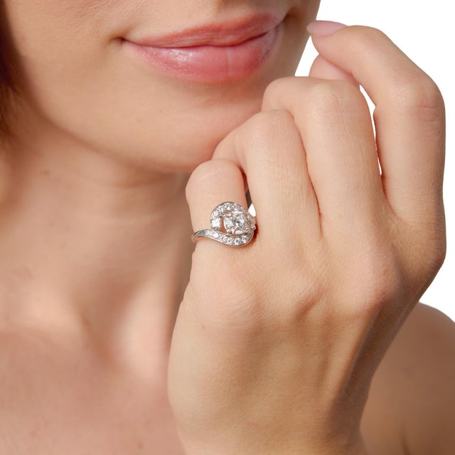 This captivating Mid Century swirl ring showcases a stunning 1.51 carat old mine cut diamond, certified by GIA...