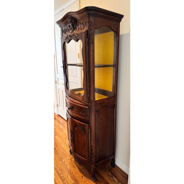 This elegant Victorian Rococo Revival corner curio cabinet features rich dark-stained hardwood with intricate hand-carved...