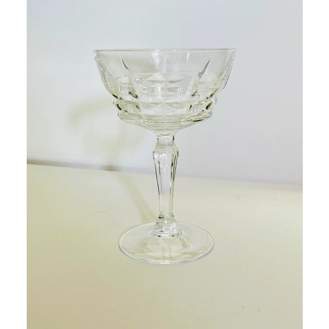 An elegant quartet of crystal champagne glasses featuring a faceted stem in excellent condition. Ships within 1-2 days...