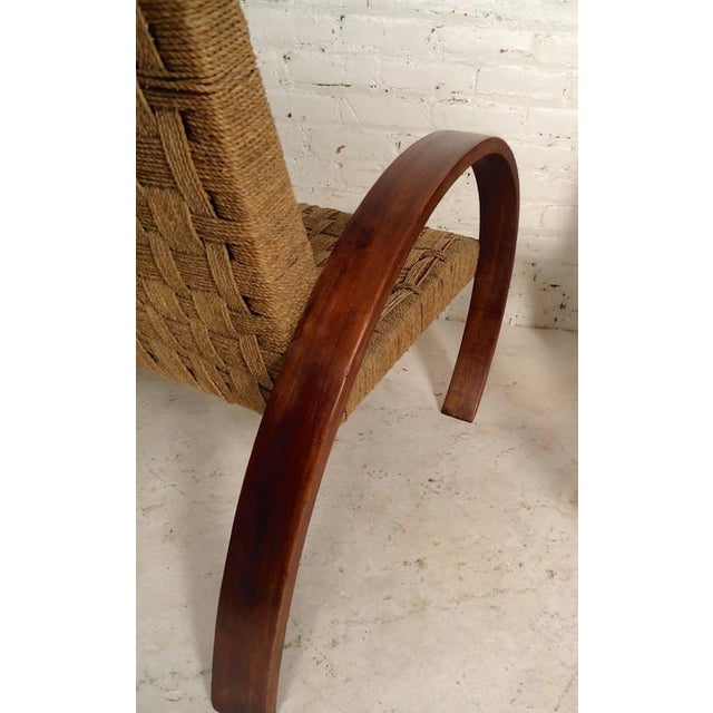 Unique pair of rope chairs beautifully designed with woven seat and back. Features exaggerated curved wooden arms that...