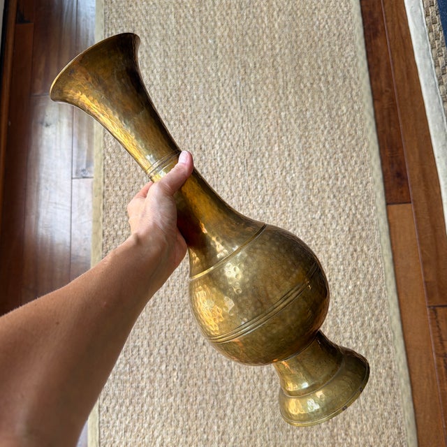 This is a vintage handcrafted brass vase from India featuring a hammered texture.