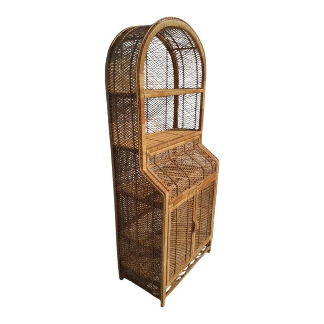 This 1970s Italian bamboo and rattan bookcase features an arched top, a fall-front desk compartment, and lower storage...