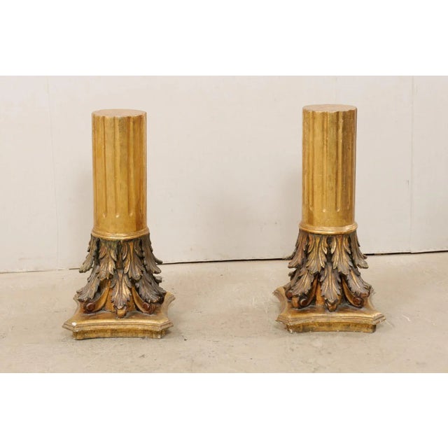 An Italian pair of carved and gilt wood pedestals from the early 20th century. This antique pair of architectural pedestal...