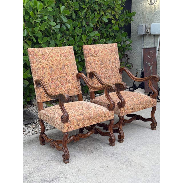 Vintage Baroque-style carved armchairs with beautifully detailed carved wood frames and an elegant, timeworn character....