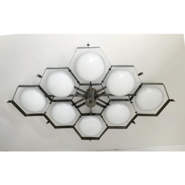 Italian midcentury flush mount with eight glossy white Murano glass shades mounted on solid brass frame in satin black...