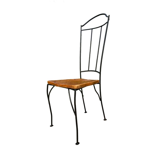 Bring warmth and character to your space with this striking rustic-modern dining chair, featuring a sculptural black iron...