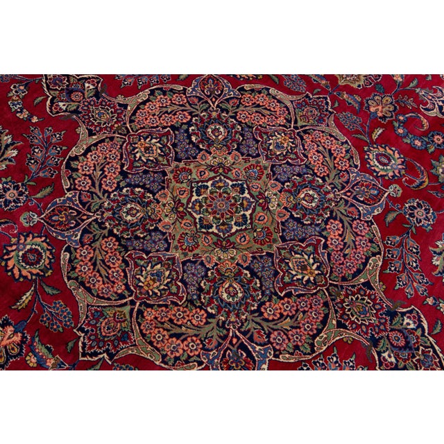 Beautiful Antique Kashan hand-knotted wool rug with a red color field. This Persian rug has a blue designed frame with...