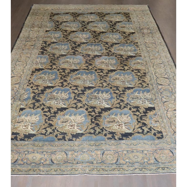 an early 20th Century Antique Persian Bidjar rug with a large scale all over floral pattern in light blues, camel, soft...