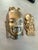 Two vintage brass masks. One looks like a Tibetan woman and the other is a holy man.