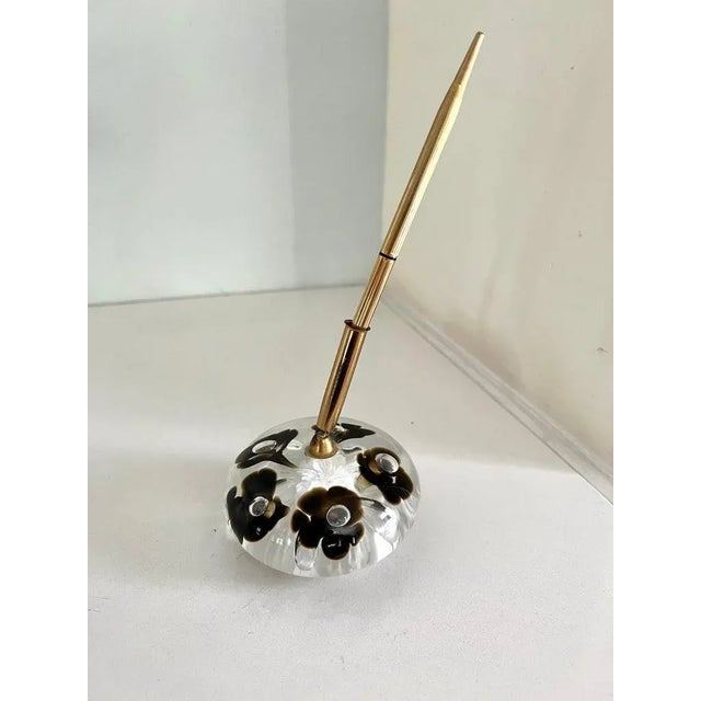 A beautiful glass paper weight with dark flowers encased - a holder for a lovely ribbed gold pen. The piece is great for...