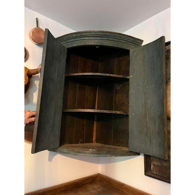 this 19th century English hanging corner cupboard, an excellent example of English provincial craftsmanship, features a...