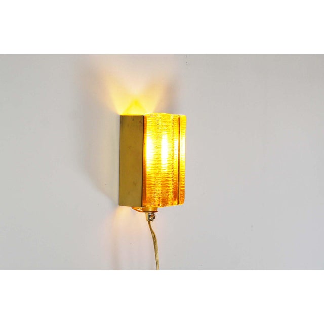 Beautifull brass and amber colored glass wall lights by Vitrika, model ‘Atlactic’. In great condition without damages to...