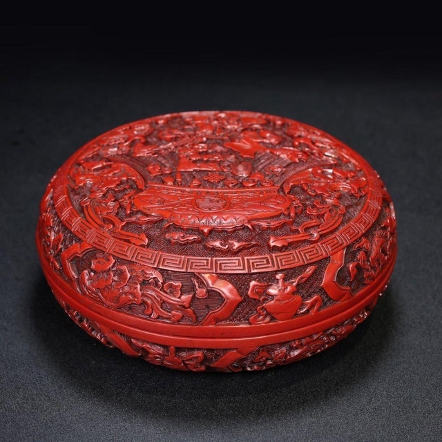This is a substantial and intricately crafted carved lacquer box, featuring deep, detailed relief work in a rich,...
