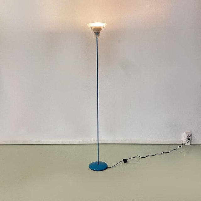 Floor lamp with blue metal structure with a round base. Inverted cone-shaped diffuser in opaque glass, with internal part...