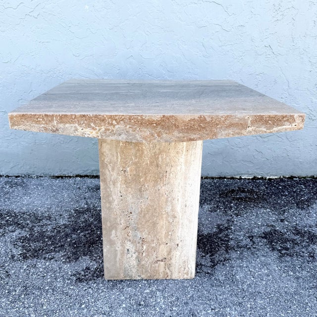 This vintage Italian side table celebrates the natural beauty of polished travertine in a striking architectural form. A...