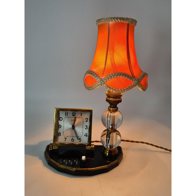 An elegant and decorative french table lamp with a built-in clock, dating from the art deco period, circa the 1930s. the...
