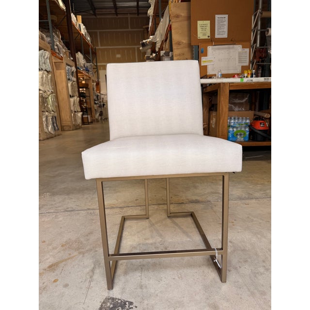 Contemporary side chair featuring clean architectural lines and a streamlined silhouette upholstered in an ivory faux...