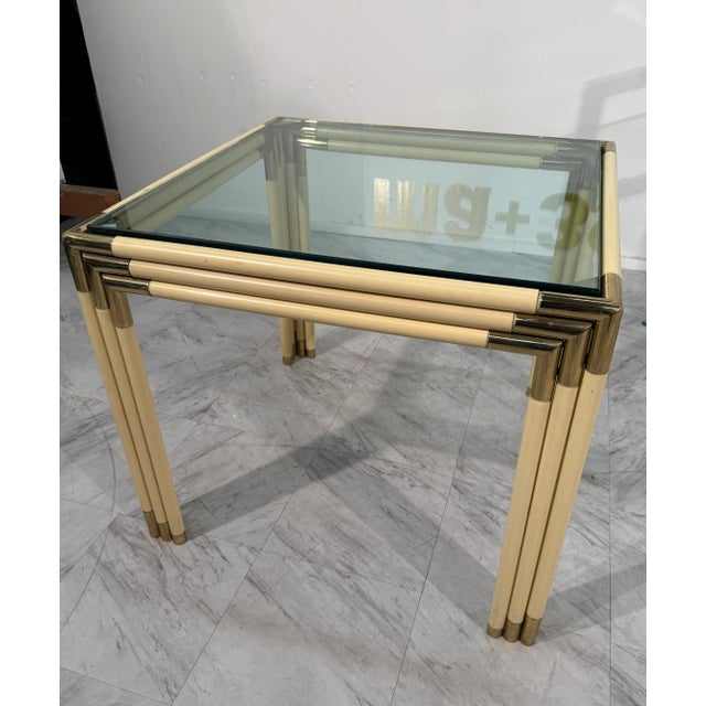 Elegant Italian mid-century modern side table from the 1970s, featuring a square glass top supported by a faux-bamboo...