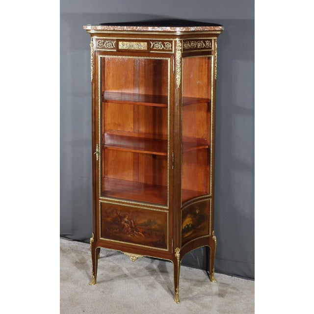 Mahogany and mahogany veneer display case opening through a dark door two thirds of the way through a window highlighted...